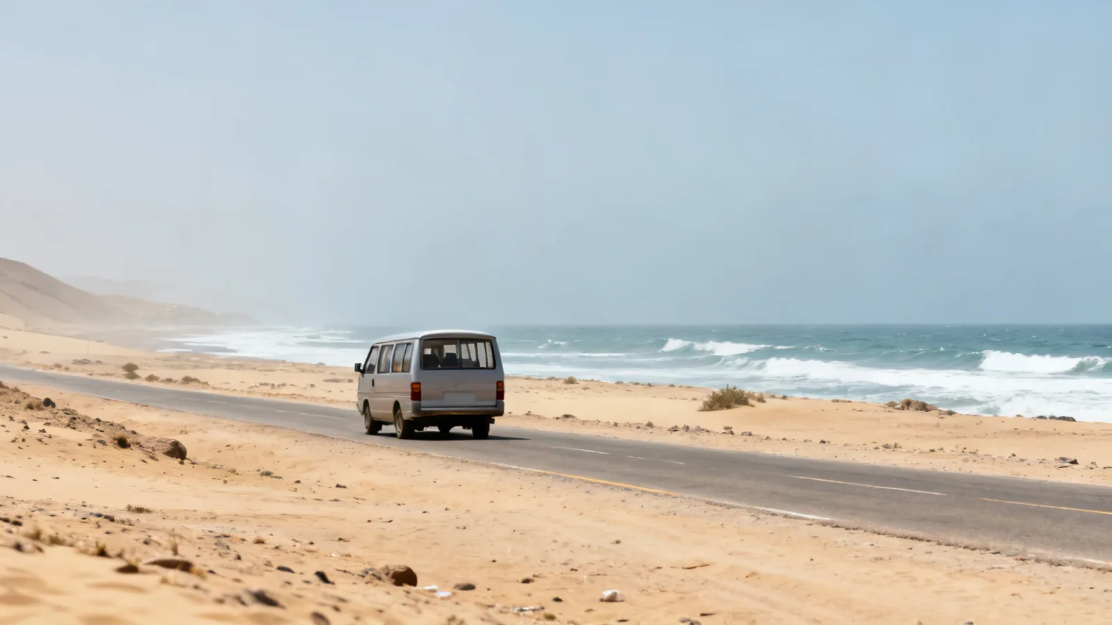 Photographic illustration of an unbranded passenger van on a coastal desert road