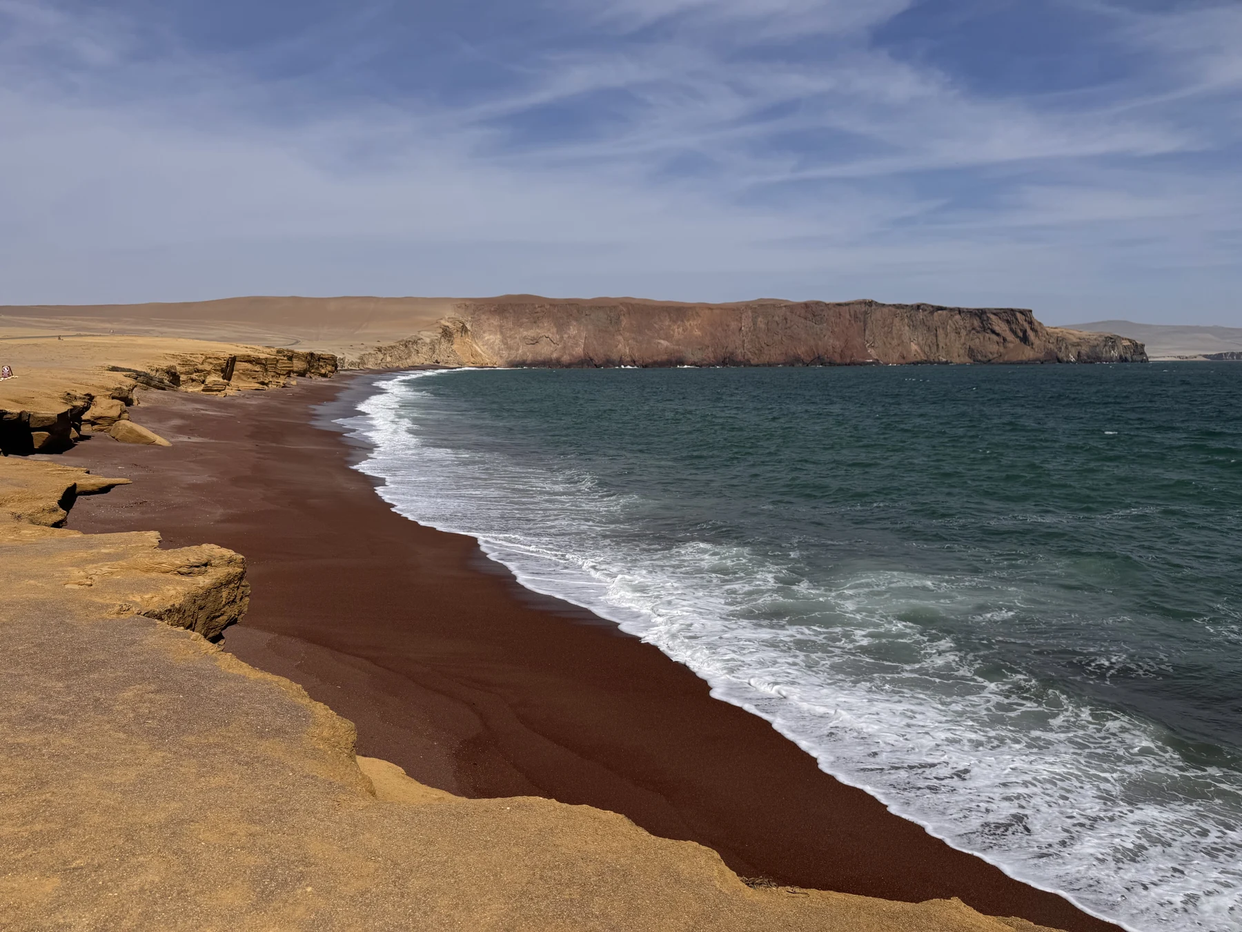 Red shore of Playa Roja below the Paracas coastal cliffs